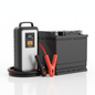 Portable car jump starter next to a car battery